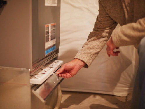A man changing a furnace filter in DePere, WI
